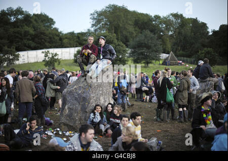 Nachtschwärmer können sich während der abendlichen Feierlichkeiten beim Glastonbury Festival am Steinkreis entspannen. Stockfoto