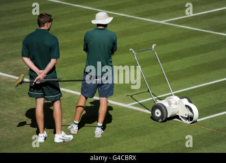 Das Bodenpersonal bereitet am vierten Tag der Wimbledon Championships 2011 im All England Lawn Tennis Club, Wimbledon, den Mittelplatz vor. Stockfoto
