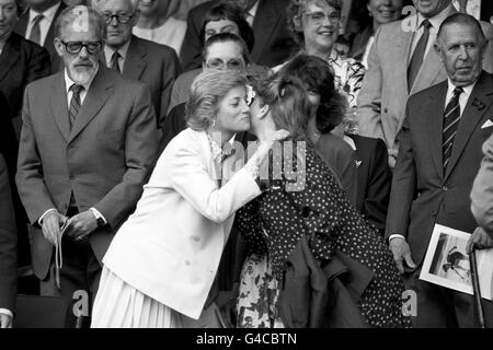 Diana Prinzessin von Wales küsst die Herzogin von York auf die Wange, als sie sich in der Royal Box am Centre Court in Wimbledon treffen. Stockfoto