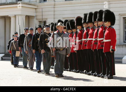 Mitglieder der Southern Skirmish Association (SoSkAn) American Civil war Re-enactment Society mit Soldaten der Grenadier Guards, während der Eröffnung des British Military Tournament in Wellington Barracks im Zentrum von London. Stockfoto