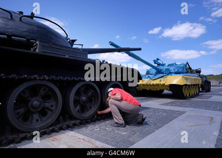 Eine ukrainische Instandhalter schmiert einen Panzer als nächstes ein russischen t-64 Tank lackiert in den Farben der Flagge der Ukraine im ukrainischen staatlichen Museum des großen Vaterländischen Krieges befindet sich am Stadtrand von Pechersk Bezirk von Kiew, der Hauptstadt der Ukraine Stockfoto