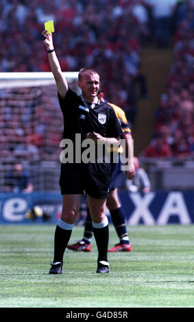 SCHIEDSRICHTER GRAHAM UMFRAGE ZEIGT EINE GELBE KARTE WÄHREND DER FA CHARITY SCHILD FUSSBALLSPIEL 1998 IM WEMBLEY STADIUM, LONDON. ARSENAL GEWANN DAS SPIEL MIT 3:0. Stockfoto