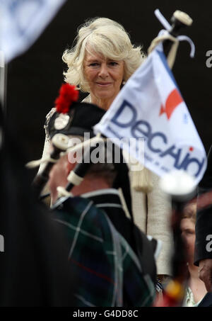 Die Herzogin von Cornwall beobachtet Decaids massierte Pfeifen- und Drums-Parade von einem Dai vor dem schottischen Parlament, bevor sie mit der Parade im Holyrood Park spricht und Mitglieder des DecAid-Teams trifft. Stockfoto