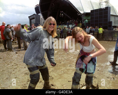 Katrina Mann (26) (links) und Amy Last (19) aus Suffolk tanzen zu Musik von Hot House Flowers und spielen auf der Pyramid-Bühne beim Glastonbury Festival, das von Schlamm und Regen überflutet wird. Stockfoto