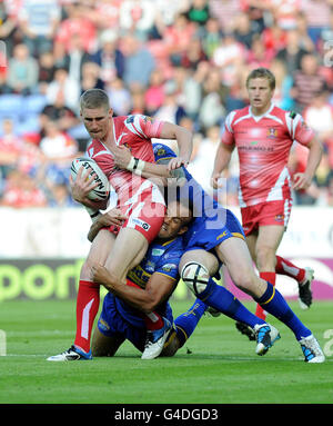 Wigans Sam Tomkins (links) wird von Leeds Jamie Jones-Buchanan (unten) und Jamie Peacock während des Engage Super League-Spiels im DW Stadium, Wigan, angegangen. Stockfoto