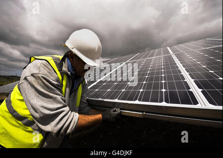 Ein Bauingenieur überprüft die Spannung der Solarpaneele auf dem ersten Solarpark im Südwesten auf dem Gelände einer stillgewirtschafteten Zinnmine in Wheal Jane in der Nähe von Truro. Stockfoto