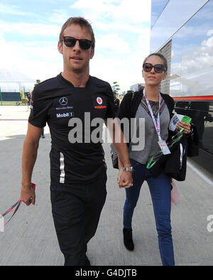 Jenson Button von McLaren Mercedes kommt mit Freundin Jessica Michibata am Fahrerlager-Tag zum British Grand Prix der Formel 1 von Santander auf dem Silverstone Circuit in Northampton in Silverstone an. Stockfoto