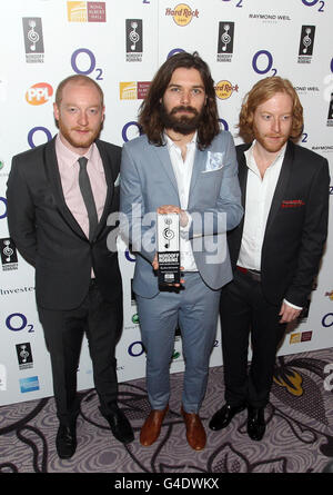 (Von links) Ben Johnston, Simon Neil und James Johnston von Biffy Clyro mit ihrem Best British Band Award bei den Nordoff Robbins O2 Silver Clef Awards im Hilton, London. Stockfoto