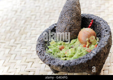 Foto von zertrümmerten Advocado, Guacamole in einem traditionellen Stein molcajete Stockfoto