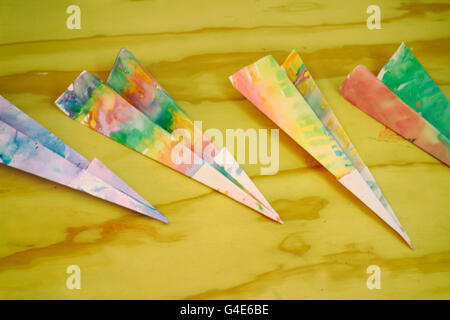 Foto von einige bunte Papierflieger auf einem Holztisch Stockfoto