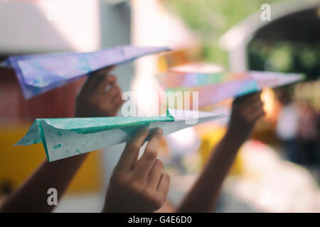 Foto von einige bunte Papierflieger auf bis zum flugfertigen Modell auf Kinderhände Stockfoto