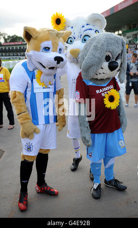 Huddersfield Town Maskottchen Terry the Terrier (links) und Scunthorpe vereint Maskottchen Scunny Bunny machen sich auf den Weg zur Startlinie Für das Sonnenblumen Sprint Maskottchen Rennen auf der Uttoxeter Rennbahn Stockfoto