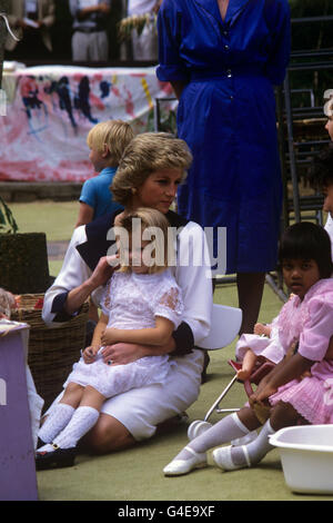 Die fünfjährige Trudy wird von der Prinzessin von Wales, die sich auf die Knie kniet, um mit Kindern im Barnado's Welfare Centre in Auburn, Sydney, zu spielen, königlich kuschelt. Stockfoto