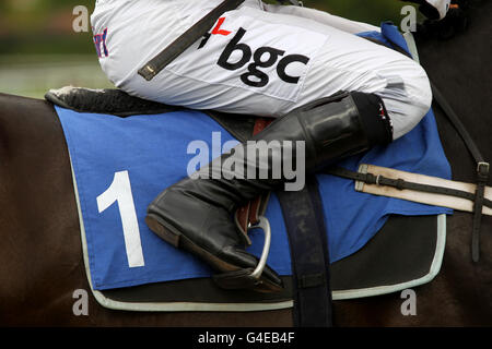 Detailansicht eines Jockeys in Steigbügeln als er Sitzt auf einem mit der Nummer 1 beschrifteten Satteltuch Stockfoto