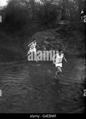 S. H. James (Oxford University), führt Bruce Tulloh (Cambridge University) während des Rennens durch das Wasser. Stockfoto