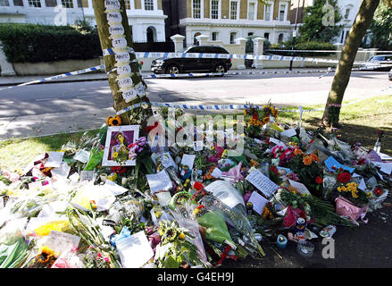 EDITOREN HINWEIS INHALT. Blumen, Tribute und Liedtexte liegen außerhalb des nördlichen Londoner Hauses von Amy Winehouse, wo sie am Samstag tot aufgefunden wurde. Stockfoto
