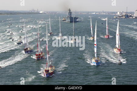 Die zehn Yachten, die beim Clipper Round the World-Yacht-Rennen gegeneinander antreten, fahren in Formation Southampton Water entlang, gefolgt von dem letzten verbliebenen Flugzeugträger der Royal Navy, HMS Illustrious, als sie ihre Umrundung beginnen. Stockfoto