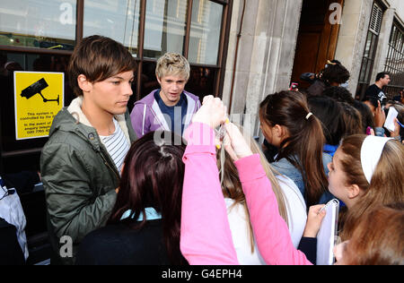 Louis Tomlinson (links) und Niall Horan von One Direction treffen Fans vor Radio 1 in London. Stockfoto