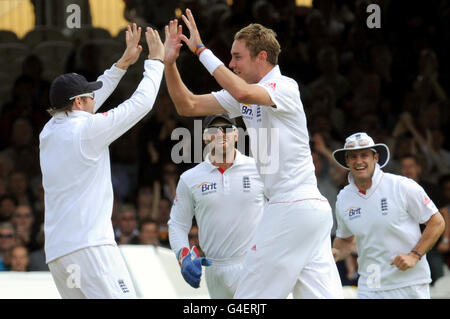 Englands Stuart Broad (Mitte) feiert mit Ian Bell (links), nachdem er den indischen Gautam Gambhir für 15 während des dritten Tages des ersten npower Tests am Lord's Cricket Ground, London, ausgekegelt hat. Stockfoto