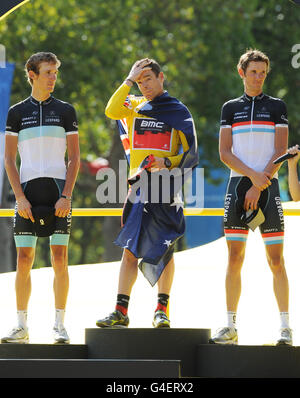 Gesamtsieger des gelben Trikots, der Australier Cadel Evans (Mitte), auf dem Podium, der Luxemburger Andy Schleck (links) auf dem zweiten Platz und sein Bruder Frank Schleck (rechts) auf dem dritten Platz nach der Tour de France auf den Champs-Elysees in Paris. Stockfoto