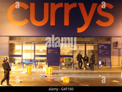 Die Polizei verhafte eine Frau vor einem Currys-Geschäft, dessen Fenster in Brixton, im Süden Londons, gebrochen worden waren, als eine zweite Nacht der Unruhen die Hauptstadt traf. Stockfoto