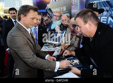 Daniel Craig gibt Autogramme für Fans, als er bei der UK Premiere von Cowboys und Aliens im O2, Greenwich, London, ankommt. Stockfoto