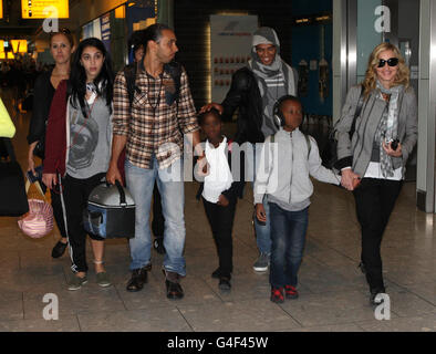 EDITOREN BEACHTEN KINDERGESICHTER PIXELIERT DURCH DEN PA-BILDTISCH. Madonna (ganz rechts) kommt aus New York am Flughafen Heathrow in London an, mit ihrem Freund Brahim Zaibat (dritte rechts) und den Kindern Lourdes Leon (zweite links), David Banda (zweite rechts) und Mercy James (Mitte). Stockfoto