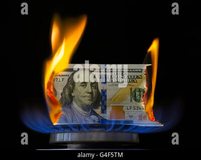 In Flammen Dollarschein. Hundert-Dollar-Schein in Gas-Brenner-Flamme brennt. Gas-Brenner brennen 100 Dollarschein auf schwarzem Hintergrund. Stockfoto