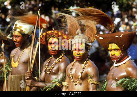 Lokale Tänzer in traditioneller Kleidung warten darauf, die Queen in Port Moresby willkommen zu heißen. Stockfoto