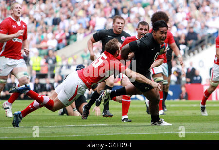 Manu Tuilagi aus England durchbricht das Tackle von Morgan Stoddart aus Wales, um während der Investec International in Twickenham, London, einen Versuch zu machen. Stockfoto