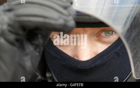 Ein Polizist an einem unbekannten Ort in London bereitet sich auf eine vierte Nacht der Unruhen in der Hauptstadt vor. Stockfoto