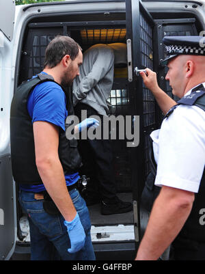 Ein 15-Jähriger wird in Brixton wegen gewaltsamer Unordnung und Einbruch verhaftet, als Metropolitan-Polizisten Adressen in Süd-London im Zusammenhang mit den jüngsten Unruhen in London überfielen. Stockfoto