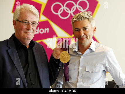 Designer der Olympischen Medaillen 2012 David Watkins mit dem ehemaligen Dreifachspringer Jonathan Edwards während einer Fotozelle im Londoner Organisationskomitee der Olympischen Spiele 2012 in Canary Wharf, London. Stockfoto