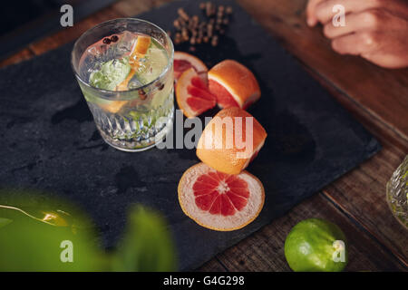 Schließen Sie herauf Bild der frisch zubereiteten cocktail Drink mit Grapefruit-Scheiben auf Tisch. Stockfoto