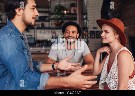 Gruppe von jungen Freunden in einem Café hängen. Junge Männer und Frauen sitzen zusammen und reden in einem Café. Stockfoto