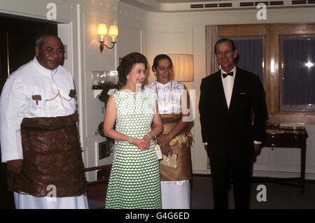 Königin Elizabeth II. Und der Herzog von Edinburgh mit König Taufa'ahau Tupou IV. Und Königin Halaevalu Mata'abo von Tonga, als sie an Bord der Royal Yacht Britannia eine Dinnerparty abhielten. Stockfoto