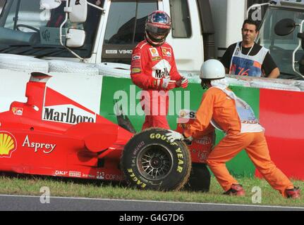 Der deutsche F1-Pilot Michael Schumacher von Ferrari blickt auf seinen gestürzten Reifen, nachdem er sich in der 32. Runde des Formel-1-Grand-Prix von Japan in Suzuka am 01. November vom Rennen zurückzog. Schumacher fuhr mit vier Punkten hinter Mika Häkkinen aus Finnland und konnte sich den Fahrertitel nicht sichern. FOTO DER PA-NACHRICHTEN Stockfoto