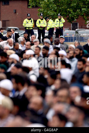 Die Polizei wacht diskret über die Beerdigung von Haroon Jahan, Shazad Ali und Abdul Musavir im Summerfield Park, Winson Green, Birmingham, vor einer privaten Beerdigung auf dem nahegelegenen Handsworth Cemetery. Stockfoto