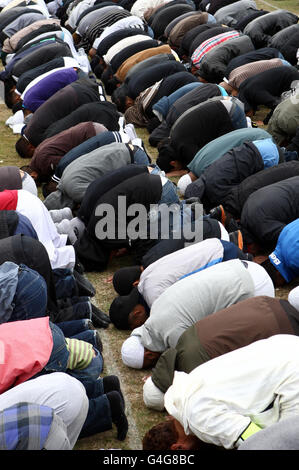 Trauernde beten während der Beerdigung von Shazad Ali, Abdul Musavir und ihrem Freund Haroon Jahan im Summerfield Park, Winson Green, Birmingham, vor einer privaten Beerdigung auf dem nahe gelegenen Handsworth Friedhof. Stockfoto