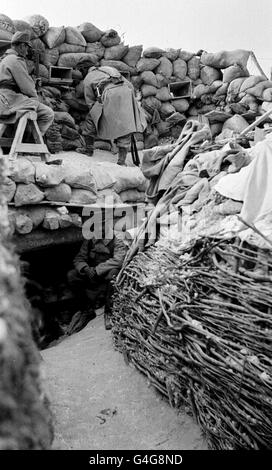 PA NEWS PHOTO 1915 DIE FRANZÖSISCHEN SOLDATEN BEWACHEN IHREN FRONTBEREICH WACHSAM, INDEM SIE WÄHREND DES ERSTEN WELTKRIEGES SCHLUPFLÖCHER IN DER SANDSÄCKEPATZE ÜBER IHREM DUGOUT NUTZEN Stockfoto