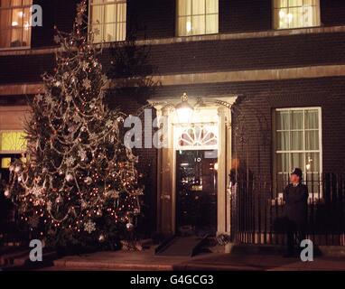 Ein Polizist bewundert den Weihnachtsbaum, der vor der Downing Street 10 steht - der offiziellen Residenz des britischen Premierministers Tony Blair. Am Montag, dem 7. Dezember 1998, wurden die Lichter des 20 m hohen Baumes von Blairs Frau Cherie eingeschaltet, die von zwei ihrer Kinder, Euan und Kathryn, und der Schauspielerin Linda Robson, zur Zeremonie in London beitrat. Siehe PA Geschichte POLITIK Lichter. PA Foto: Toby Melville. Stockfoto