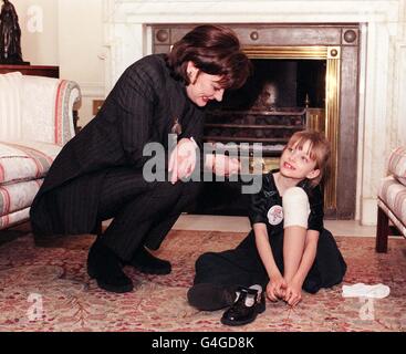 Cherie Blair, Ehefrau von Premierminister Tony Blair, sieht zu, wie die achtjährige Laura Giddings aus dem New Forest bei den heutigen (Weds) 1998 Woman's Own Children of Courage Awards in Downing Street ihren falschen Fuß zeigt. Laura war im Sommer auf einem Familienurlaub in Kapstadt, Südafrika, als sie von einem Bombenanschlag in einem Planet Hollywood Restaurant erwischt wurden. Lauras Fuß war so stark beschädigt, dass er amputiert werden musste. Foto von Fiona Hanson. Siehe PA Story POLITIK Kinder. Stockfoto