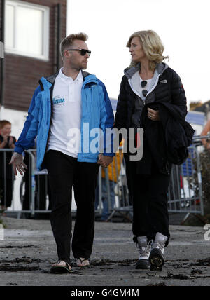 Ronan Keating und Frau Yvonne vor dem Schwimmstart schwimmen eine Spendenaktion über die Irische See zugunsten der Krebsforschung in Großbritannien bei Holyhead. Stockfoto