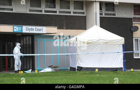 Ein Polizeibeamter arbeitet am Tatort vor den Wohnungen des Clyde Court in Wortley, Leeds, nachdem zwei Menschen beim Sturz aus dem Turmblock ums Leben kamen. Stockfoto