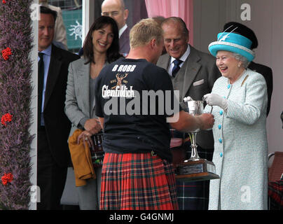 Königin Elizabeth II. Überreicht Auszeichnungen, die der Herzog von Edinburgh und Premierminister David Cameron (links) und seine Frau Samantha (2. Links) beim Braemar-Treffen in Braemar verfolgen. Stockfoto