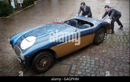 Mitarbeiter von Bonhams, London, mit einem Ex-Werk Le Mans 24-Stunden-Rennen 1953-55 Austin-Healey '100' Special Test Car, einer von nur vier jemals gebaut, die von Bonhams zur Versteigerung auf der Mercedes-Benz World in Weybridge am Donnerstag, 1. Dezember präsentiert wird, erwartet über 500,000 zu holen. Stockfoto