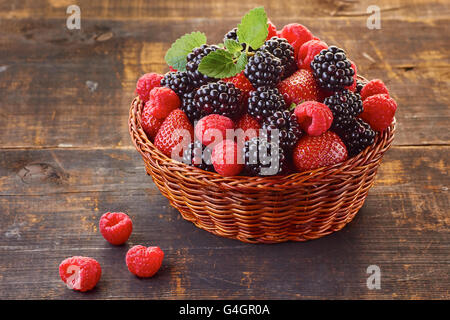 Korb Vith Brombeeren, Erdbeeren und Himbeeren auf Holztisch Stockfoto