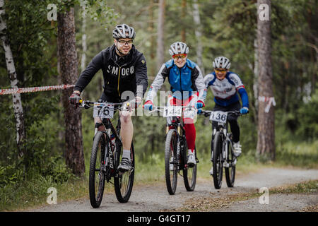 Gruppe von männlichen Radfahrer Reiten durch Wald im cross-country-Rennen "Neue Energie" Stockfoto