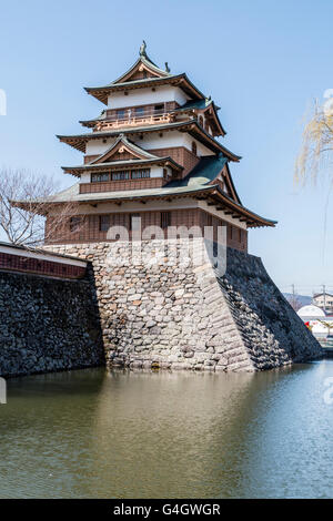 Japan, Suwa. Rekonstruierte Takashima schloss mit Haupt halten an der äußeren Wand hoch über dem Graben gegen den blauen Himmel in den frühen Frühling. Stockfoto