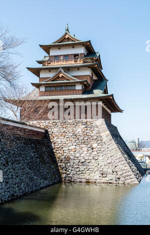 Japan, Suwa. Rekonstruierte Takashima schloss mit Haupt halten an der äußeren Wand hoch über dem Graben gegen den blauen Himmel in den frühen Frühling. Stockfoto